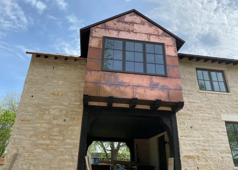 Copper metal panel facade on a stone building for Skylight Installation in Turpin Hills